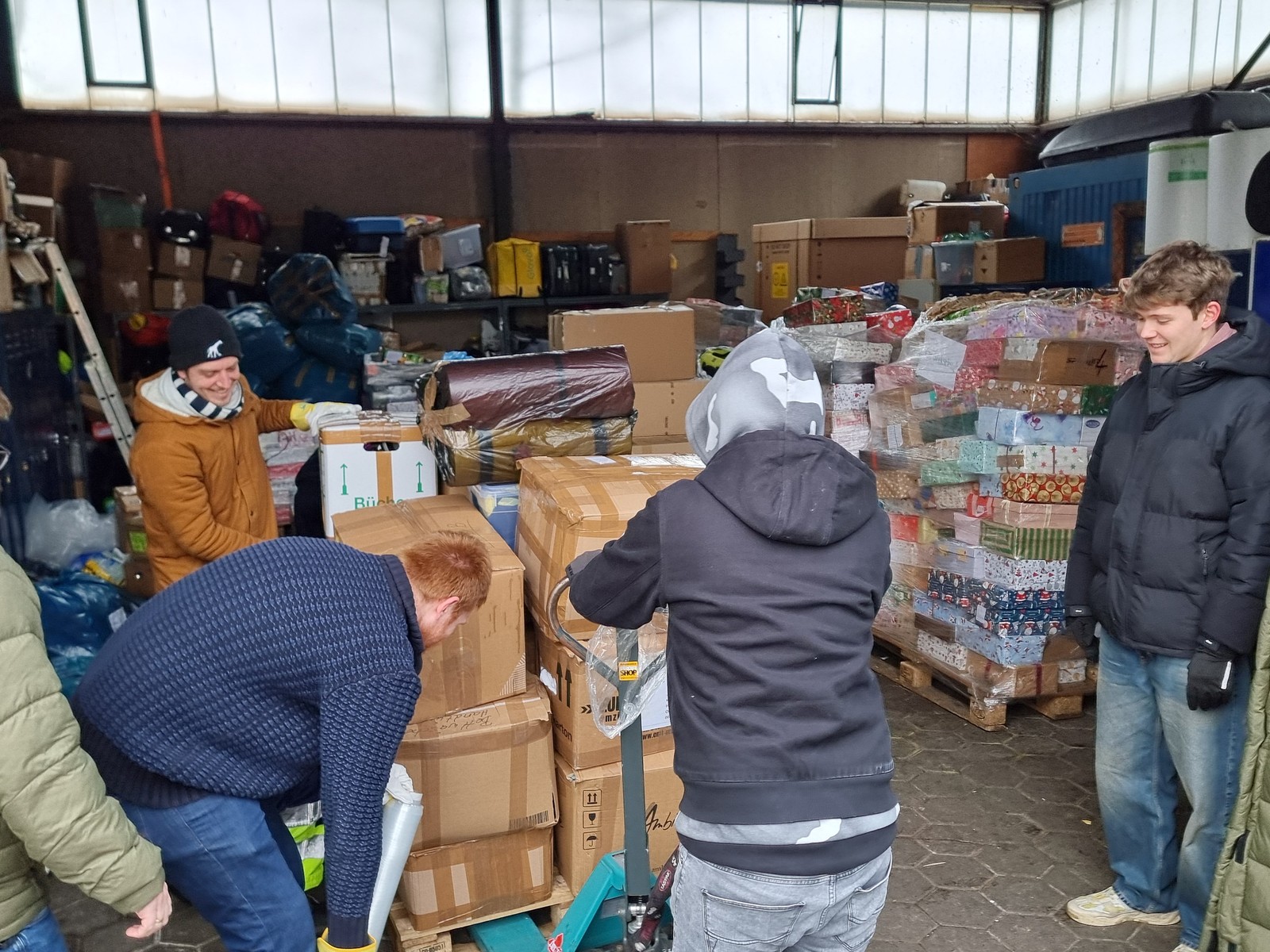 Ehrenamtliches Team der Ukraine Hilfe Hamburg packt im Lager Hilfsgüter auf Paletten
