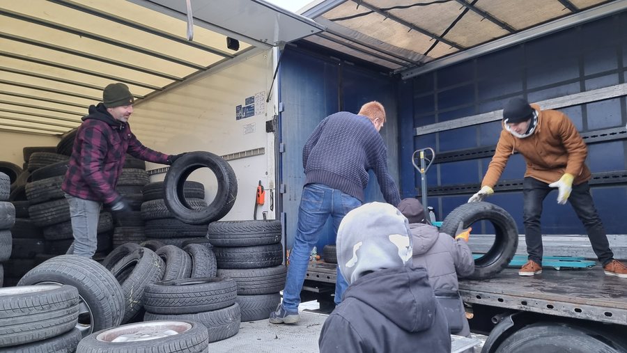 Ehrenamtliche Helfer laden Reifen in einen LKW für einen Hilfstransport in die Ukraine